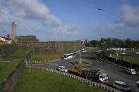 People wait hoping to receive cooking gas and fuel outside the 17th century built Dutch fortress, opposite Galle International Cricket Stadium ahead of the first test cricket matches between Australia and Sri Lanka in Galle, Sri Lanka, Tuesday, June 28, 2022. (AP Photo/Eranga Jayawardena)