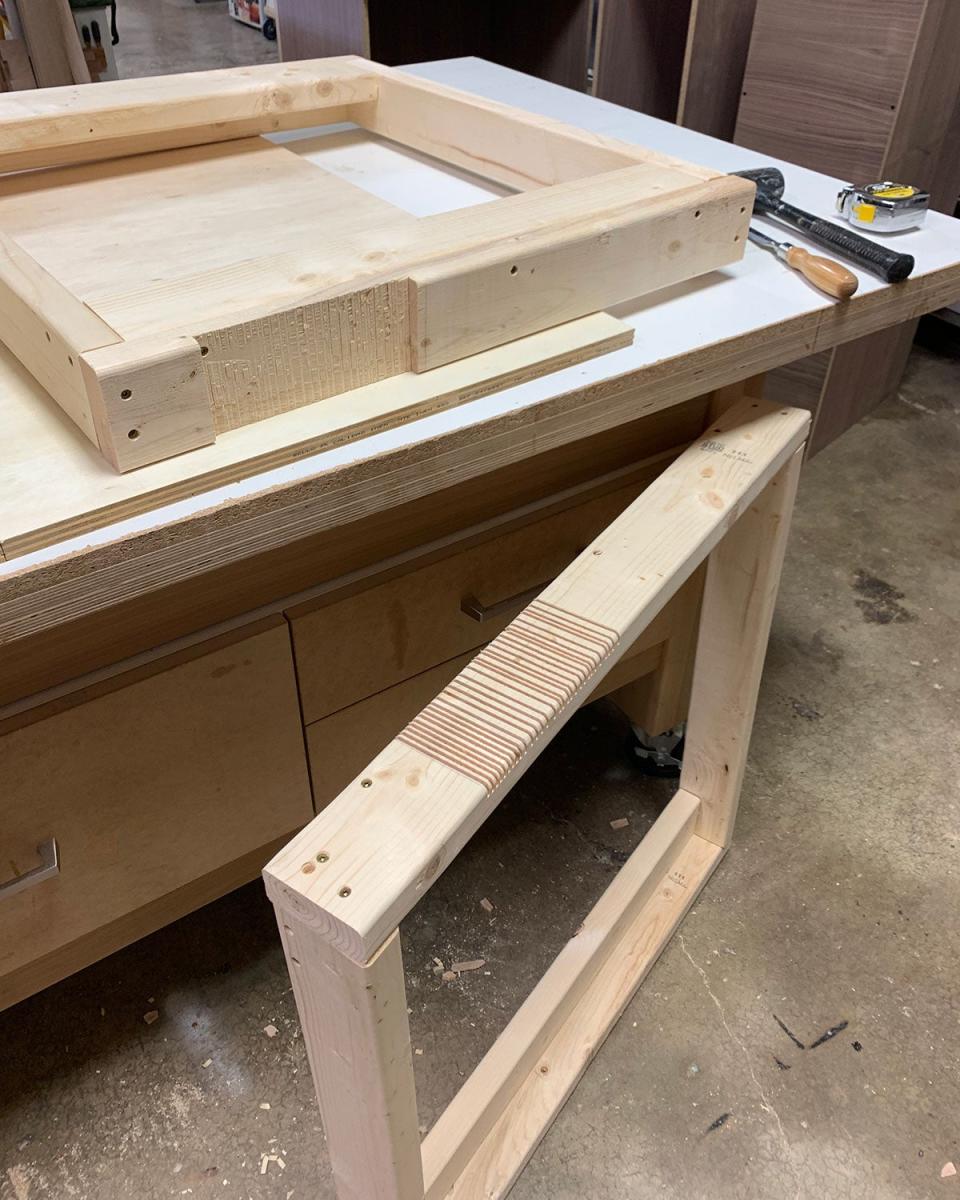 Two workbench parts in a workshop with a mallet and wood chisel.