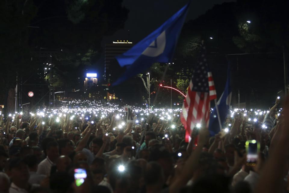 Antigovernment protesters use the flashlights of their mobile phones during a rally in Tirana, Friday, June 21, 2019. The opposition is boycotting the local elections planned for June 30 and has threatened to disrupt them.(AP Photo/Hektor Pustina)