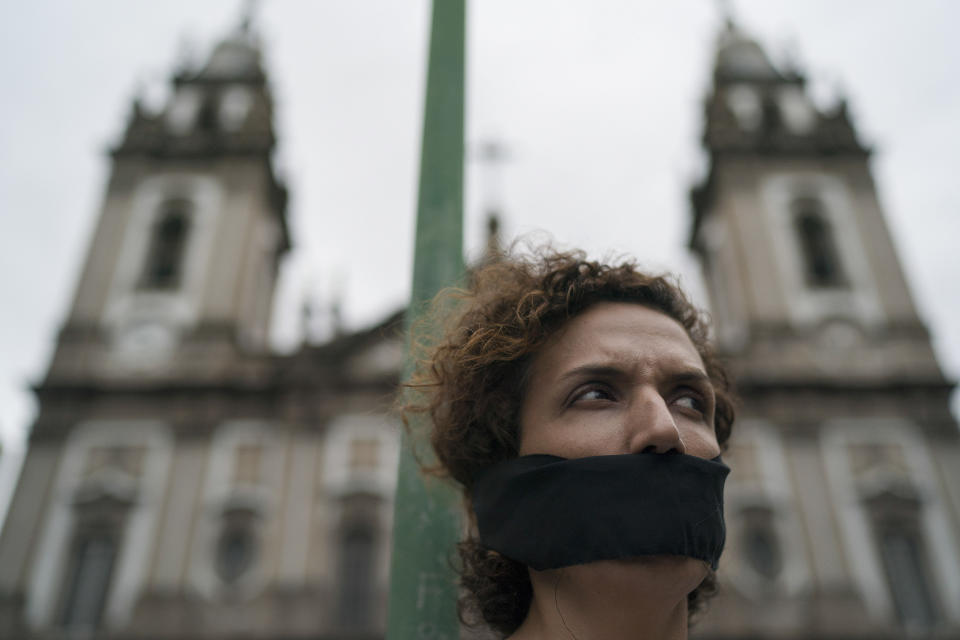 A woman wears a gag over her mouth during an event to remember the victims of Brazil's dictatorship, in downtown Rio de Janeiro, Brazil, Saturday, Dec. 8, 2018. The action was also a way to open a talk about the Dec. 13, 1968 decree known as AI-5 (Institutional Act number 5), which was when the most violent period of the dictatorship in the country started. (AP Photo/Leo Correa)