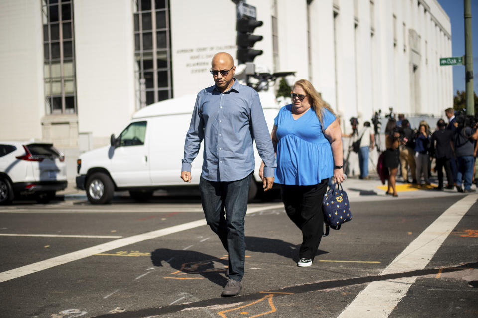 David Gregory, who's daughter Michela Gregory died in the 2016 Ghost Ship warehouse fire, leaves Alameda County Superior Court on Monday, Aug. 19, 2019, in Oakland, Calif. At right is Karen Bourdon Frieholtz. Three jurors were dismissed Monday for undisclosed reasons on the 10th day of deliberations in the trial of two men charged in the deaths of 36 partygoers from a fire inside a cluttered San Francisco Bay Area warehouse. (AP Photo/Noah Berger)