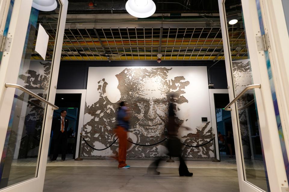 People walk past a mural depicting former Miami Dolphins football coach Don Shula, inside Hard Rock Stadium in Miami Gardens, Fla., Sunday, Oct. 16, 2022. (AP Photo/Rebecca Blackwell)