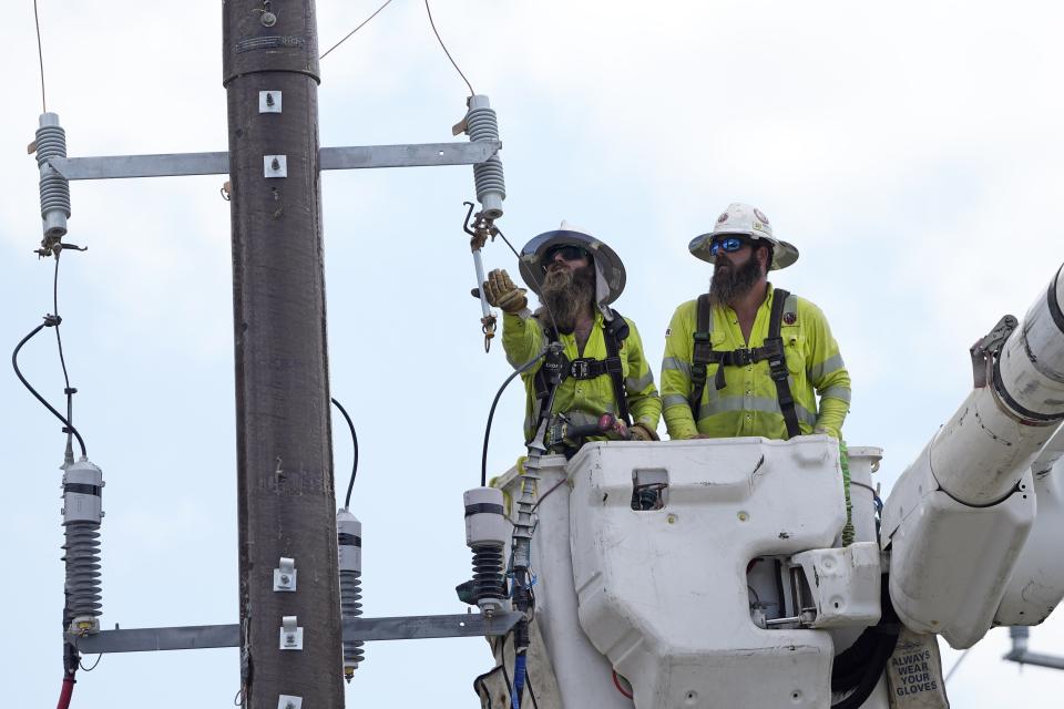 Workers repair a power line on Thursday, June 29, 2023, in Houston. An unrelenting heat wave in Texas is testing the state's power grid as demand soars during a second week of triple-digit temperatures. (AP Photo/David J. Phillip)