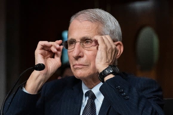 Dr. Anthony Fauci, director of the National Institute of Allergy and Infectious Diseases, adjusts his glasses during a Senate hearing