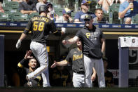 Pittsburgh Pirates' Jacob Stallings (58) is congratulated in the dugout after hitting a solo home run during the sixth inning of a baseball game against the Milwaukee Brewers, Sunday, June 13, 2021, in Milwaukee. (AP Photo/Aaron Gash)