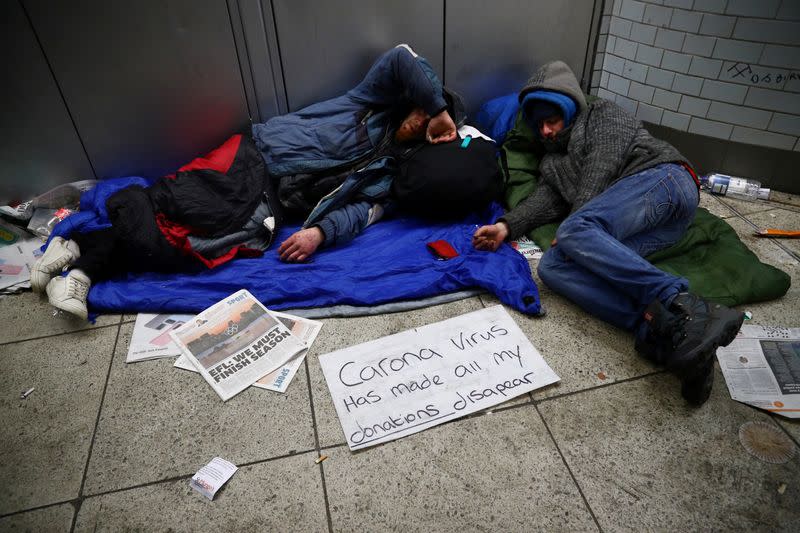 FILE PHOTO: Homeless people inside Westminster underground station display a sign