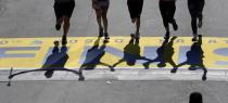 FILE - In this April 18, 2016, file photo, runners' shadows precede them across the finish line of the 120th Boston Marathon in Boston. Due to the COVID-19 virus pandemic, the 124th running of the Boston Marathon was postponed from its traditional third Monday in April to Monday, Sept. 14, 2020. (AP Photo/Charles Krupa, File)