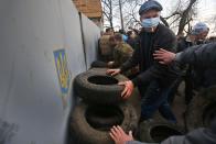 Pro-Russian activists make barricades in front of the gate of an airport in Kramatorsk, eastern Ukraine, Tuesday, April 15, 2014. In the first Ukrainian military action against a pro-Russian uprising in the east, government forces clashed Tuesday with about 30 armed gunmen at a small airport in Kramatorsk. (AP Photo/Sergei Grits)