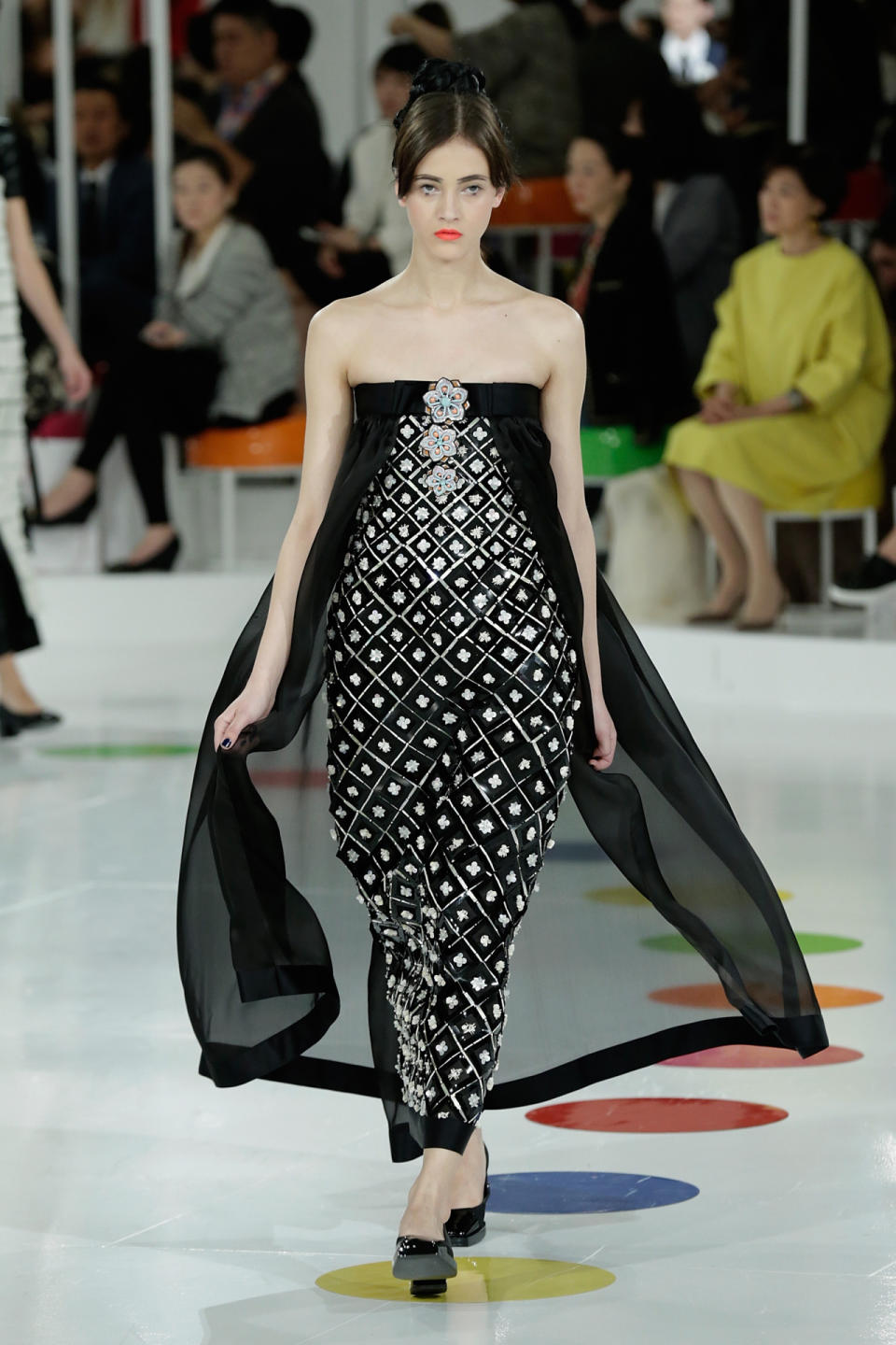 Everyone’s getting in on the cape trend — even Chanel! Karl Lagerfeld, never one to follow the pack, came up with his own version of the superfluous but stunning detail on this black and white embellished dress.