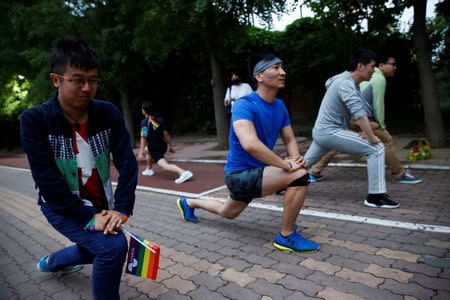 Participants warm up for a 5.17 km run to mark International Day Against Homophobia in a park in Beijing, China, May 17, 2018. REUTERS/Thomas Peter