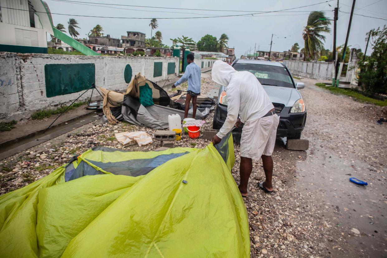 Men set up tents for shelter as heavy rain brought by tropical storm Grace hits Haitians just after a 7.2-magnitude earthquake struck Haiti on Aug. 17, 2021, in Les Cayes, Haiti.