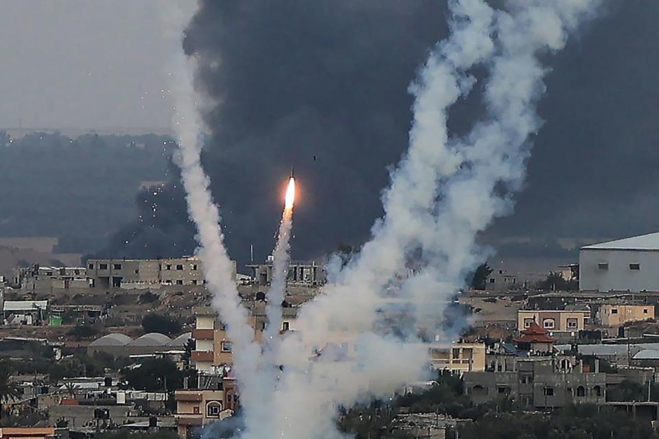A photo including Palestinian militants firing rockets toward Israel from Rafah, southern Gaza Strip