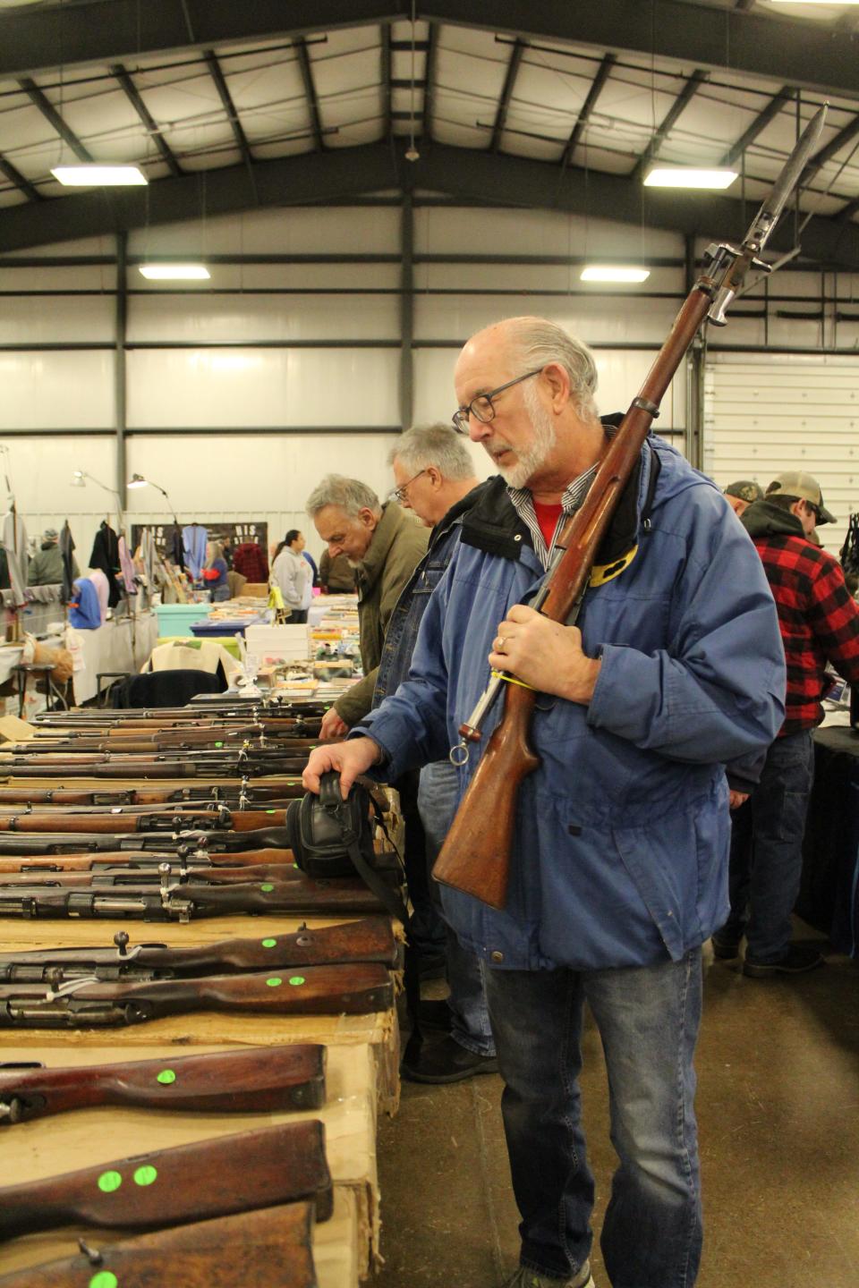 Ohio resident Steve Sauder walked the aisles at the Monroe Gun & Knife Show carrying a Swiss 1911 rifle with a bayonet and ammunition he was hoping to sell for $1,100. Provided by Kennedy Bowling