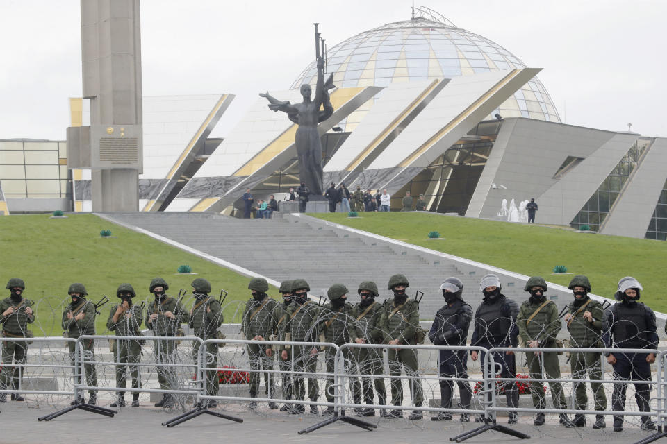 Riot policemen block the area during protests in Minsk, Belarus, Sunday, Aug. 23, 2020. More than 100,00 protesters demanding the resignation of Belarus' authoritarian president are rallying in a vast square in the capital, continuing the massive outburst of dissent that has shaken the country since dubious presidential elections two weeks ago. (AP Photo/Dmitri Lovetsky)