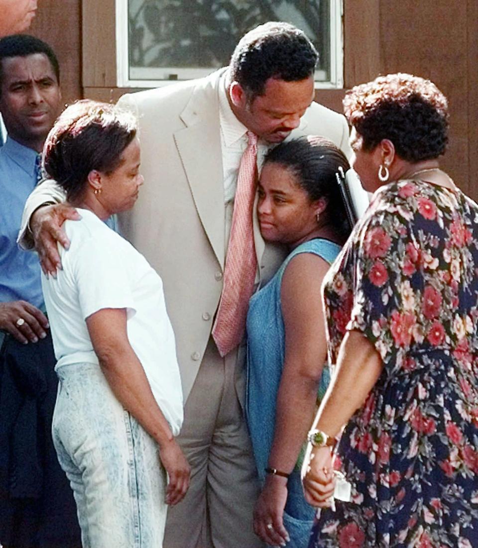 Rev. Jesse Jackson, center, hugs Renee Mullins, in blue, the daughter of James Byrd Jr., while visiting the Byrd family Wednesday, June 10, 1998, in Jasper, Texas. James Byrd Jr. was chained to pickup truck and dragged to his death along a rural East Texas road near Jasper. Three white men have been charged with his murder. Others shown are unidentified. (AP Photo/David J. Phillip) ORG XMIT: XJAS111