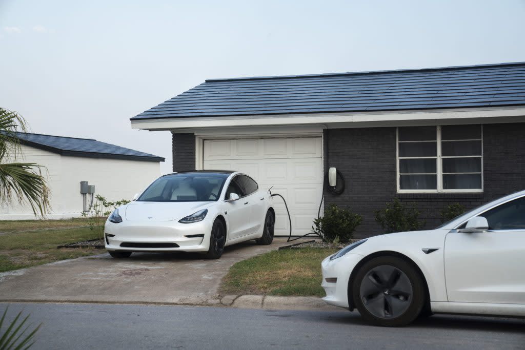 Tesla vehicles parked outside a home with a Tesla Solar Roof on Weems Street in Boca Chica Village, Texas, U.S., on Monday, June 21, 2021. Elon Musk, co-founder and chief executive officer of Tesla Inc. and Space Exploration Technologies Corp. (SpaceX), has many priorities competing for his attention, but recently has become intensely focused on Teslas Solar Roof, a niche product that enjoys demand from wealthy consumers but has proven to be a bear to install more cost effectively. Photographer: Veronica G. Cardenas/Bloomberg via Getty Images