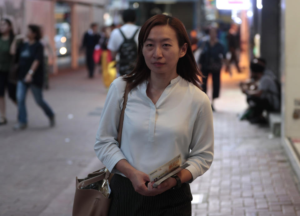In this photo taken Thursday, Nov. 7, 2019, district council candidate Cathy Yau walks during her campaign at Causeway Bay in Hong Kong. Yau. a former police officer, grew exasperated as police used more force to quell the unrest. She quit the force in July after 11 years and is running in Sunday's district polls that are widely expected to deliver a decisive victory for the six-month-old movement seeking democratic reforms in the semi-autonomous Chinese territory. (AP Photo/Dita Alangkara)