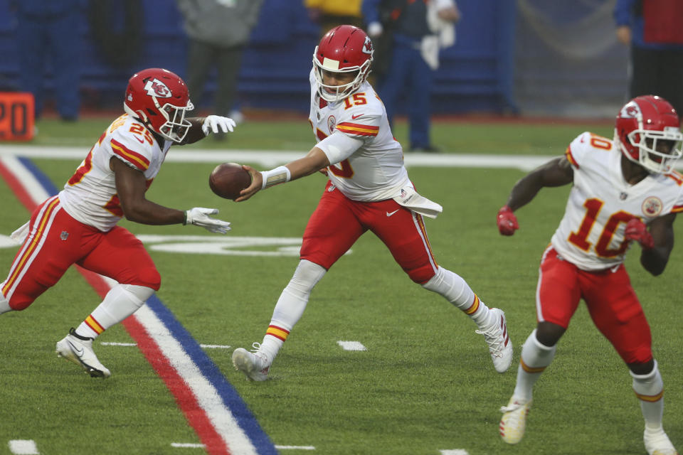 Kansas City Chiefs quarterback Patrick Mahomes, center, hands off the ball to Clyde Edwards-Helaire, left, during the first half of an NFL football game against the Buffalo Bills, Monday, Oct. 19, 2020, in Orchard Park, N.Y. (AP Photo/Jeffrey T. Barnes)