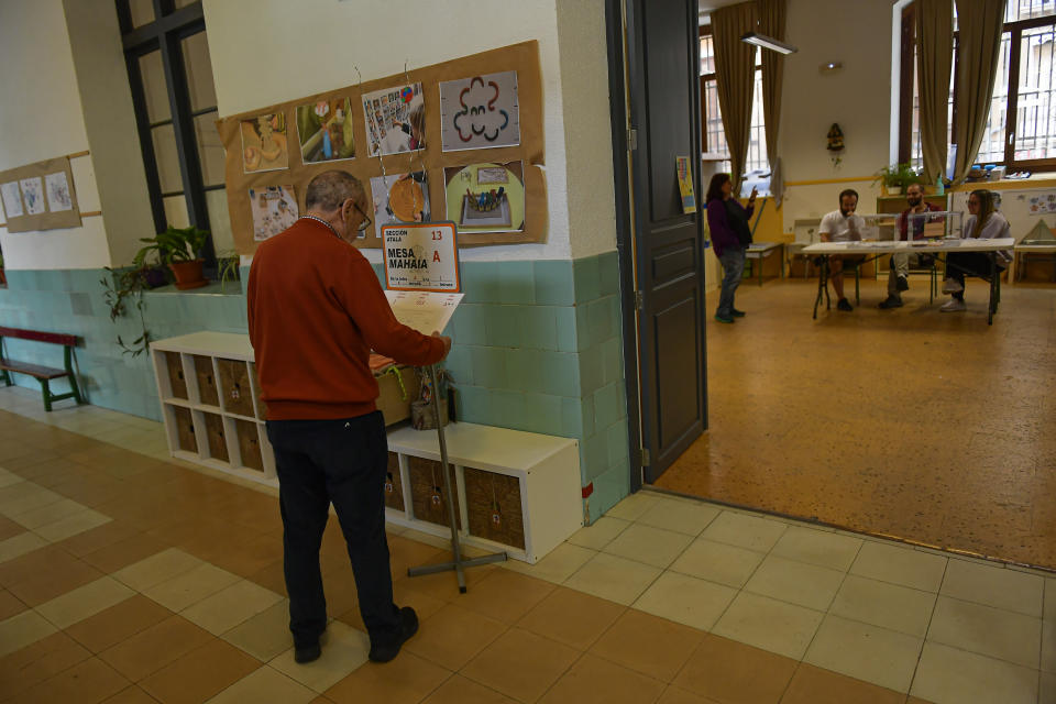 A resident checks a list in a polling station before casting his vote in a regional election in Pamplona, northern Spain, Sunday, May 28, 2023. (AP Photo/Alvaro Barrientos)