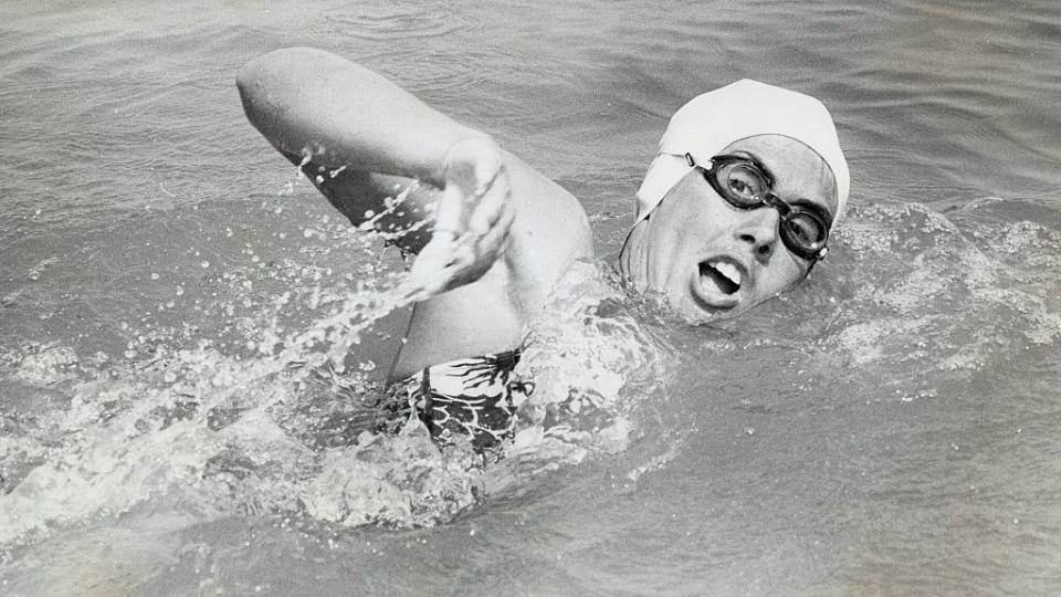 a black and white photo of diana nyad swimming