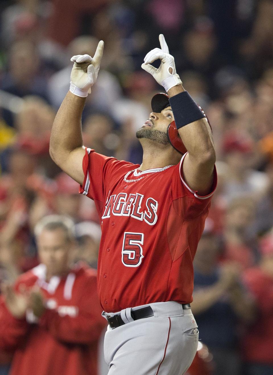 Los Angeles Angels Albert Pujols points upwards as he crosses home plate after hitting a two-run homer against Washington Nationals Taylor Jordan in the fifth inning of a baseball game in Washington, Tuesday, April 22, 2014. This was Pujols 500th career home run. (AP Photo/Pablo Martinez Monsivais)