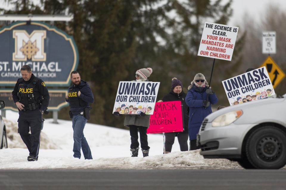 <span class="caption">Protesters in support of ending mask mandates and COVID-19 restrictions in schools hold signs outside a school in Kemptville, Ont., in February.</span> <span class="attribution"><span class="source">THE CANADIAN PRESS/Nick Iwanyshyn</span></span>