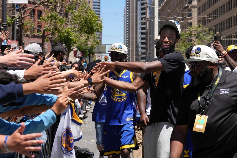 Golden State Warriors forward Andrew Wiggins celebrates with fans during the team's championship parade in downtown San Francisco.