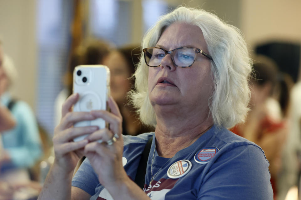 Mary Beth Smith, of Columbus, takes a photo of election results during a watch party Tuesday, Aug. 8, 2023, in Columbus, Ohio. (AP Photo/Jay LaPrete)