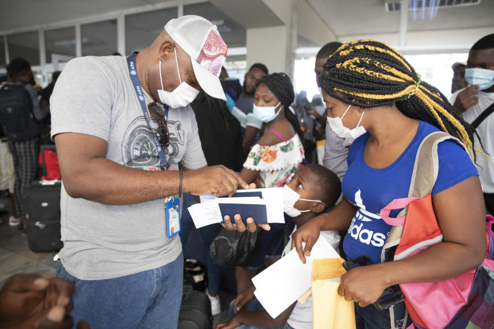 Etienne Ilienses revisa los documentos de su familia antes de viajar a Chile en el Aeropuerto Internacional Toussaint Louverture de Puerto Príncipe el 30 de enero del 2022. (AP Photo/Odelyn Joseph)