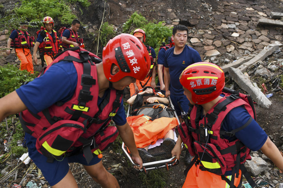 In this photo released by Xinhua News Agency, rescuers carry an injured person from a flood-hit village in Mentougou district on the outskirts of Beijing on Tuesday, Aug. 1, 2023. China's capital has recorded its heaviest rainfall in at least 140 years over the past few days after being deluged with heavy rains from the remnants of Typhoon Doksuri. (Ju Huanzong/Xinhua via AP)