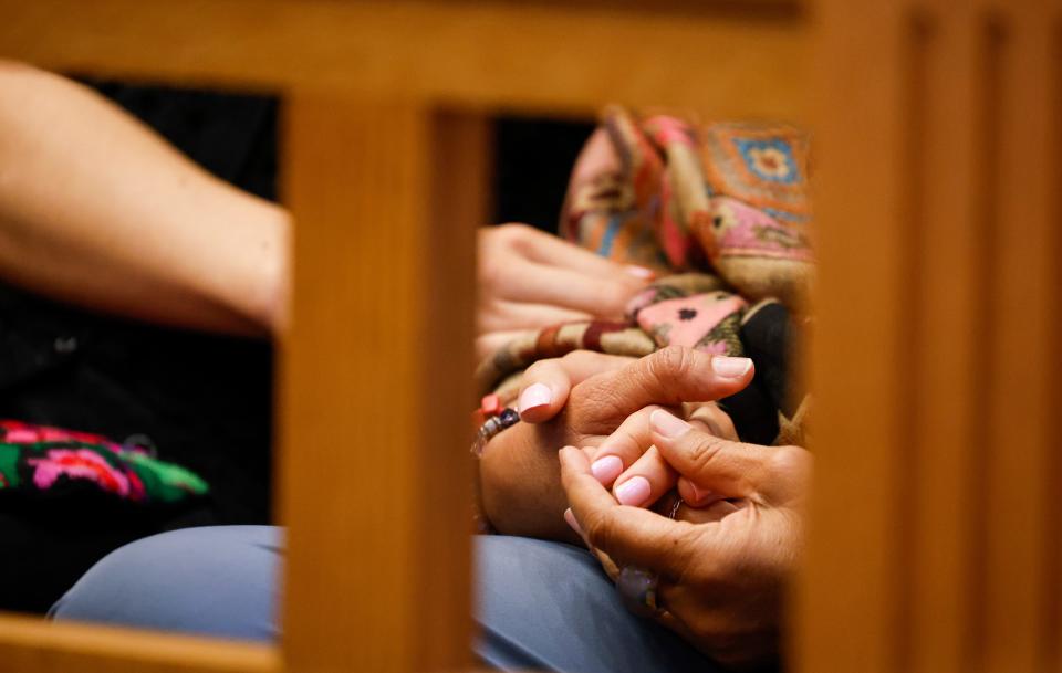 Relatives of Nohema Graber hold hands as photos are shown in court during the sentencing of Willard Miller at the Jefferson County Courthouse in Fairfield on Thursday.