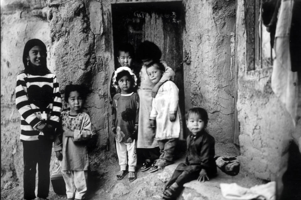 Children gather outside their house near the remnants of the giant Buddha statue destroyed by the Taliban in 2001, in Bamiyan, Afghanistan, Sunday, June 18, 2023. (AP Photo/Rodrigo Abd)