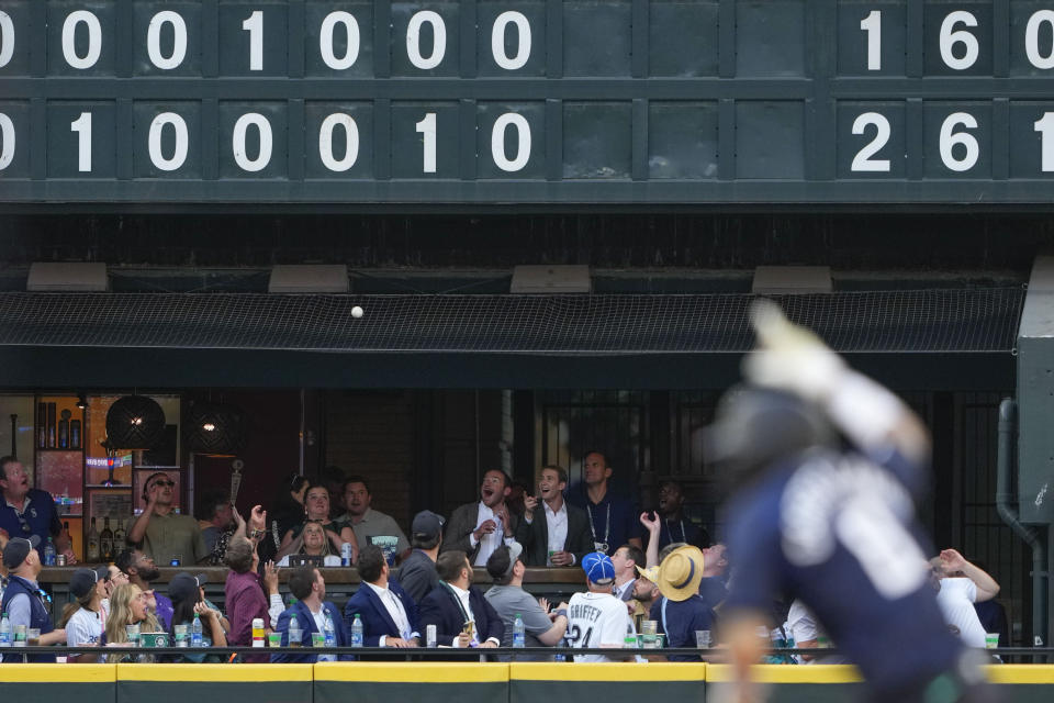 Fans reach for a two run home run ball by National League's Elias Díaz, of the Colorado Rockies (35), in the eighth inning during the MLB All-Star baseball game in Seattle, Tuesday, July 11, 2023. (AP Photo/Lindsey Wasson)