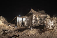 A tent where smugglers stay while building fishing boats to be used to carry migrants to the Canary Islands, is set up in a remote part of the desert out of the town of Dakhla in Morocco-administered Western Sahara, Tuesday, Dec. 22, 2020. (AP Photo/Mosa'ab Elshamy)