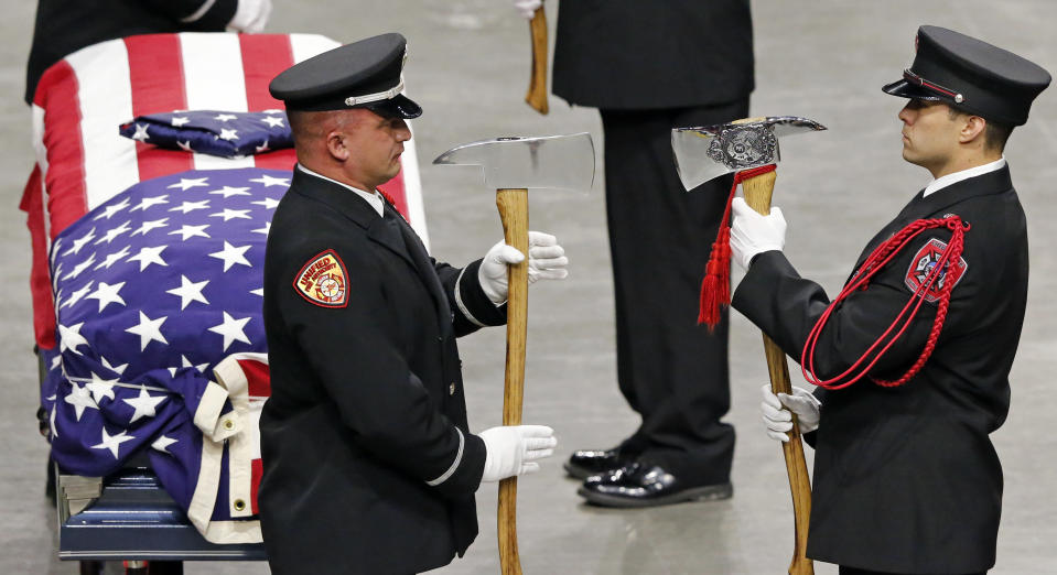 The Honor Guard stands at attention in front the casket of Battalion Chief Matt Burchett of the Draper Fire Department during funeral services Monday, Aug. 20, 2018, in West Valley City, Utah. Burchett died Aug. 13 from falling tree debris after a load of fire retardant was dropped on the area where he was working. (AP Photo/Rick Bowmer)