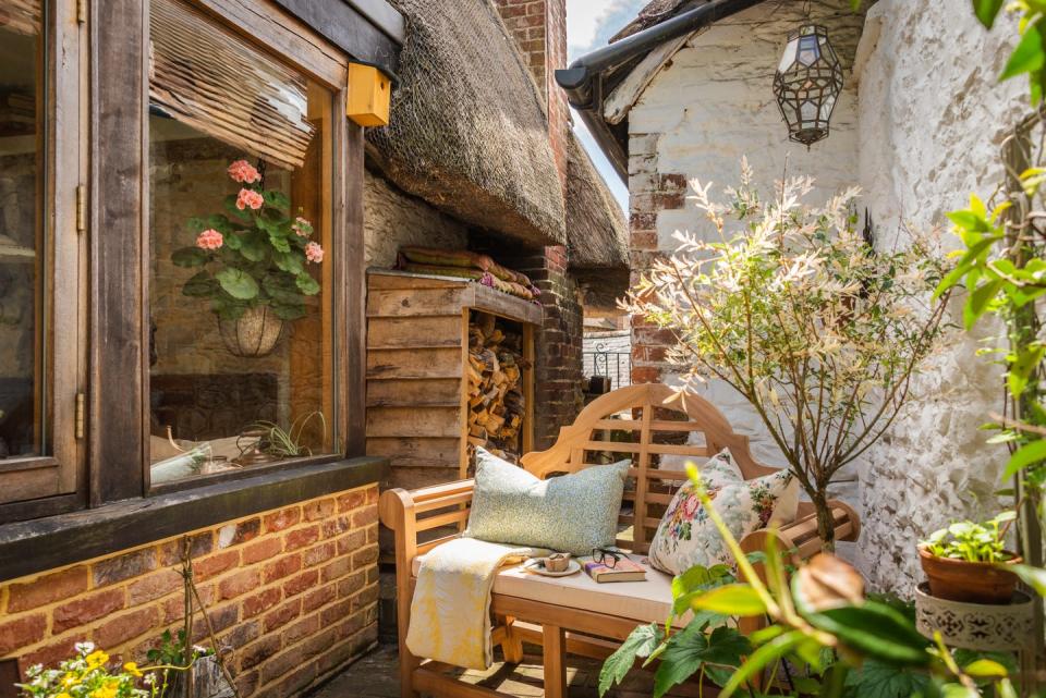 thatched cottage garden with wooden logs