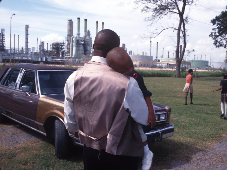 A family leaves Sunday church services surrounded by chemical plants in October of 1998 in Lions, Louisiana along 'Cancer Alley.'