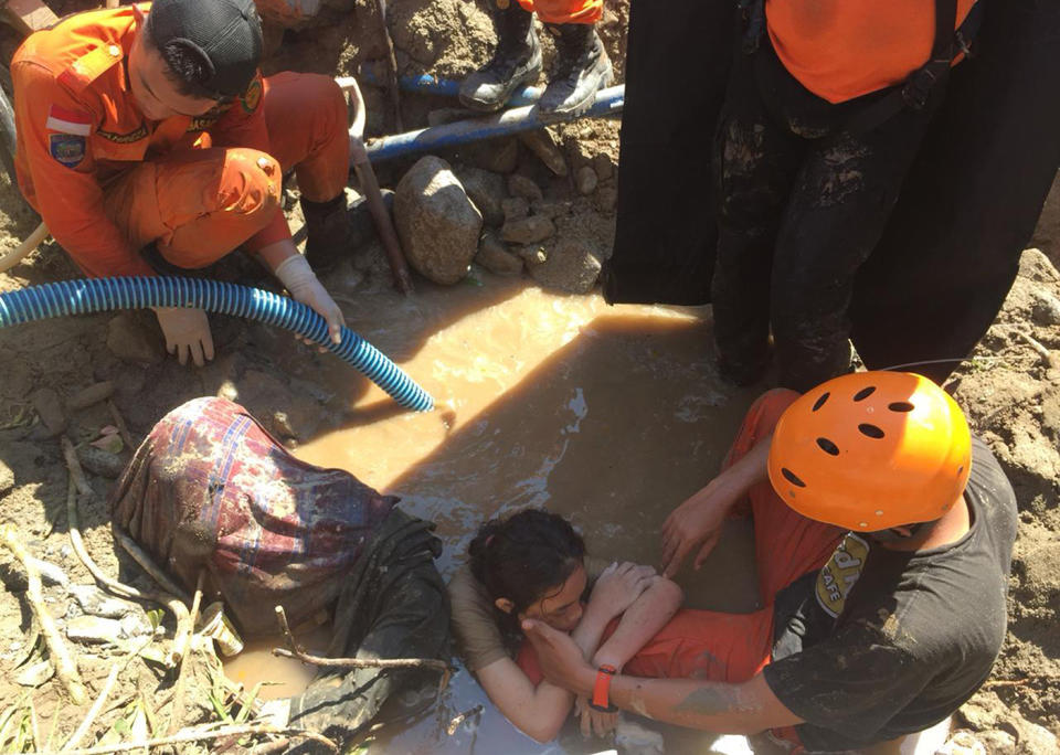 Indonesia rescue team evacuate a women from damage on Sunday following earthquakes and a tsunami in Palu. Source: AP Photo via AAP