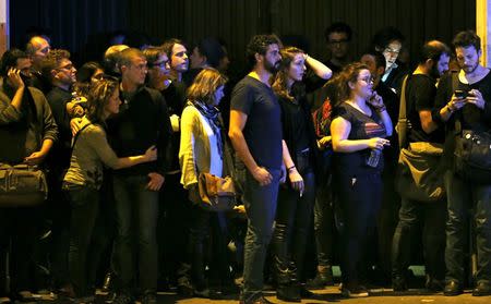 People react as they gather to watch the scene near the Bataclan concert hall following fatal shootings in Paris, France, November 13, 2015. REUTERS/Christian Hartmann