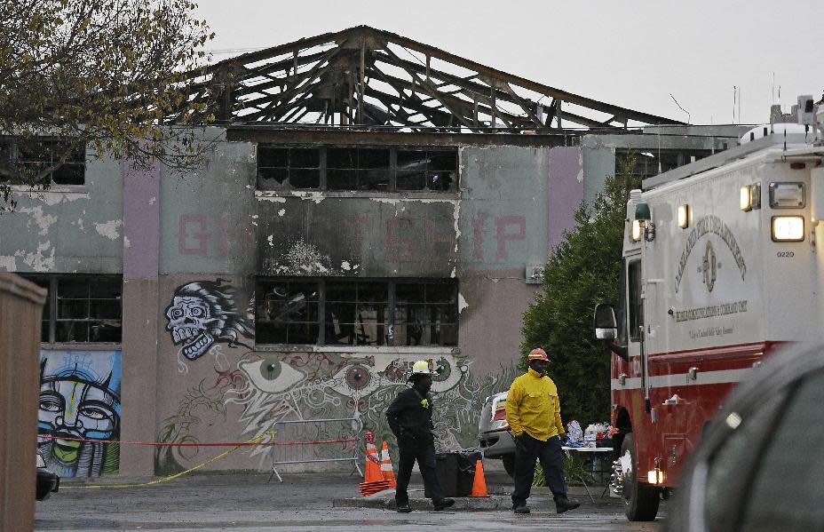 FILE - In this Dec. 7, 2016 file photo, Oakland fire officials walk past the remains of the Ghost Ship warehouse damaged from a deadly fire in Oakland, Calif. The landlord of an Oakland warehouse where 36 people died in a fire earlier this month has retained a Southern California-based attorney. Attorney Keith G. Bremer of Bremer Whyte Brown & O'Meara will represent Chor Ng, who owns the Ghost Ship property in East Oakland. (AP Photo/Eric Risberg, file)