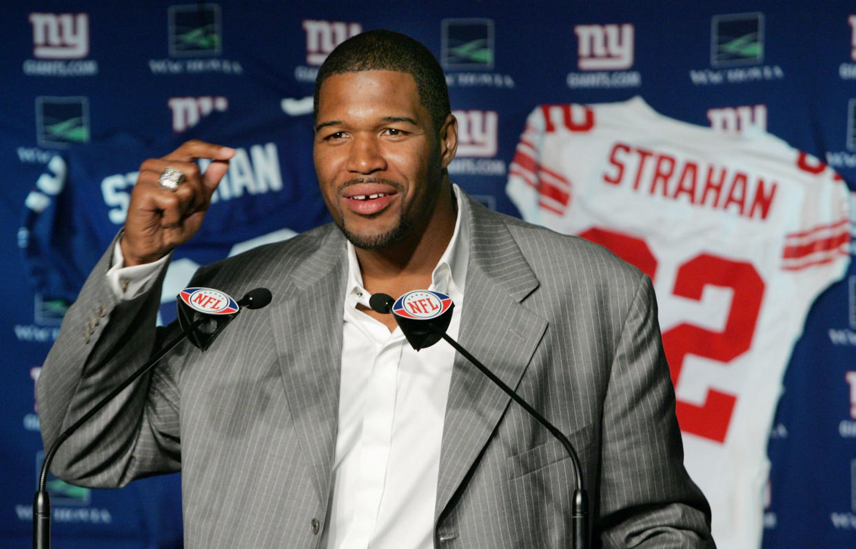 Michael Strahan speaking at a podium.