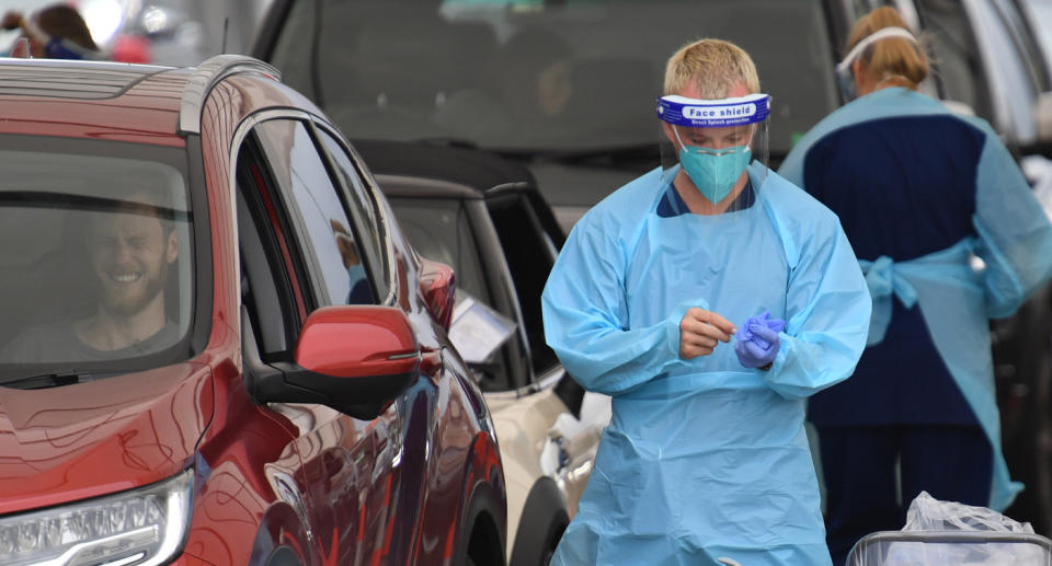 Coronavirus tester in Bondi next to driver with sour facial expression.