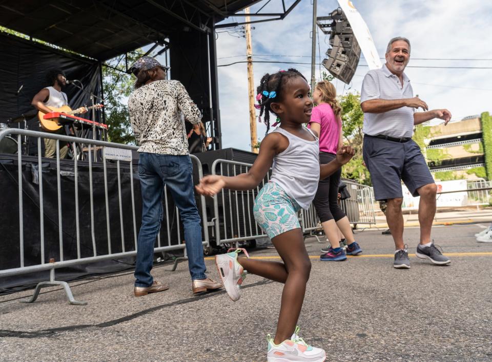 Justice Mickens, 4, of Detroit, dances with others as Aaron Lewys performs on a stage during Arts, Beats & Eats in downtown Royal Oak on Sept. 2, 2022.