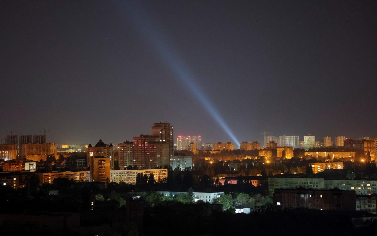 Ukrainian forces use searchlights to look for drones during a Russian strike