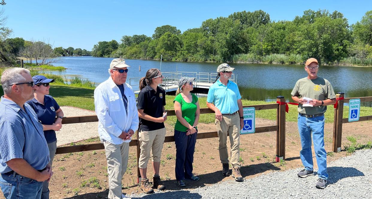 Steve Heimerman, right, of the Oconto Sportsmen's Club, talks about the project to improve the club's shoreline on the Oconto River, which included 1,200 feet of riprap and a new handicap-accessible dock (seen the background), at a program on Aug. 2, to thank those who made the project possible. From left are Ken Dolota, head of the Oconto County Land and Water Conservation Department; Betsy Galbraith of the U.S. Fish & Wildlife Service in Green Bay; Charles Wooley, USFW's Great Lakes Region director; Trina Soyk of USFW in Green Bay; Peshtigo-based DNR fish biologist Tammie Paoli; and Jim Zellmer, the deputy division administrator overseeing water projects for the Wisconsin Department of Natural Resources.