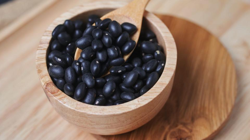 a wooden cup of black bean on the table