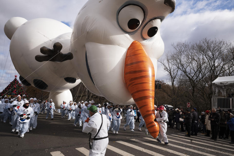 A balloon handler holds the Olaf balloon by the nose as strong winds keep Macy's Thanksgiving Day Parade balloons low to the ground, Thursday, Nov. 28, 2019, in New York. (AP Photo/Mark Lennihan)