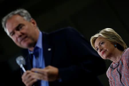 Democratic U.S. presidential candidate Hillary Clinton listens as U.S. Senator Tim Kaine (D-VA) speaks during a campaign rally at Ernst Community Cultural Center in Annandale, Virginia, U.S., July 14, 2016. REUTERS/Carlos Barria