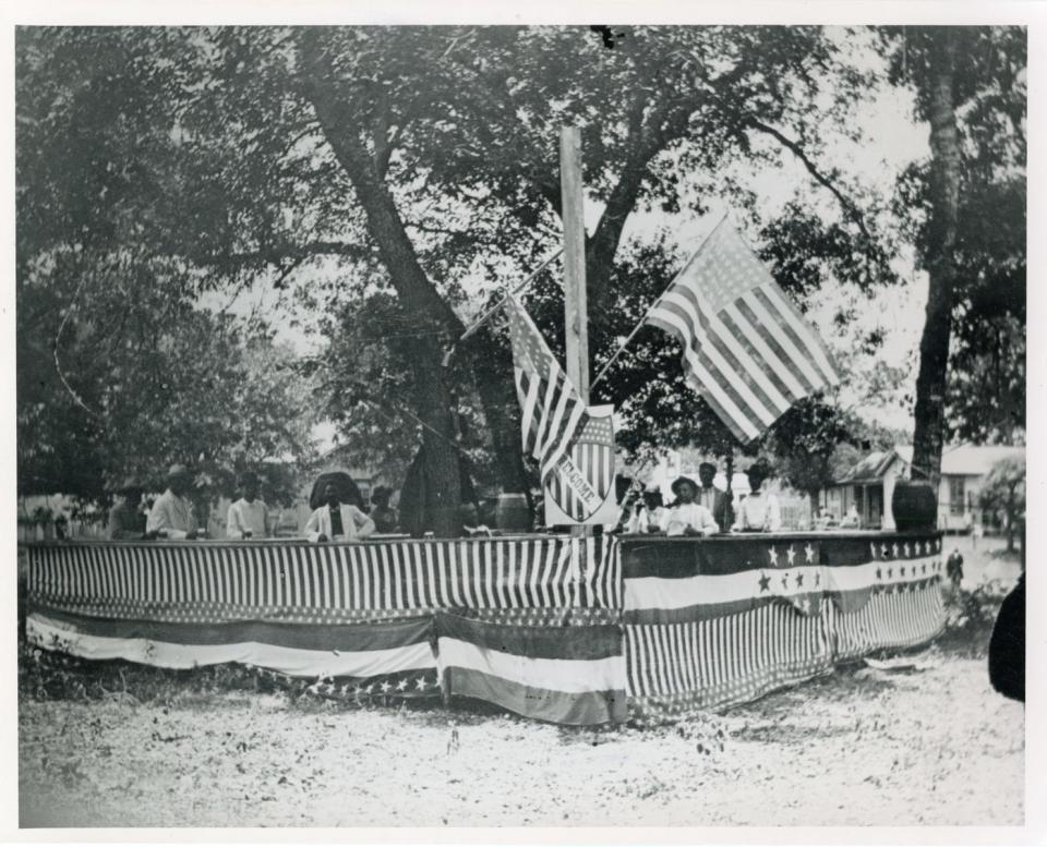  Flags and bunting greet the returned soldier at the Emancipation Day Juneteenth Celebration at Eastwoods Park, north of UT Campus, June 19, 1900.