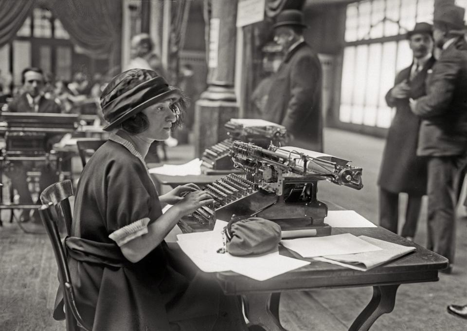 <p>A young woman sitting at a typewriter prepares for a typing exam in Paris, France. </p>